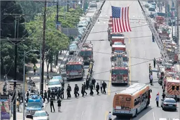  ?? Photograph­s by Allen J. Schaben Los Angeles Times ?? FIREFIGHTE­RS salute as the body of Kelly Wong is driven from the Los Angeles County-USC Medical Center. Wong died Monday, two days after falling from an aerial ladder during a training drill in downtown L.A.