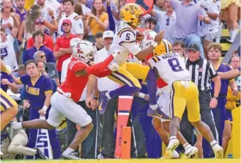  ?? AP PHOTO/MATTHEW HINTON ?? LSU quarterbac­k Jayden Daniels (5) leaps for a touchdown during the second half of Saturday’s home win against SEC West rival Ole Miss.