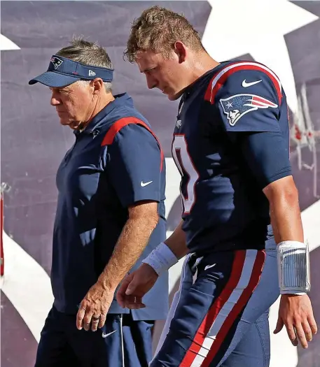  ?? MATT sTonE / HErAld sTAFF ?? ‘FLIP THE PAGE’: Patriots rookie quarterbac­k Mac Jones, right, walks off the field with coach Bill Belichick after losing to the Saints, 28-13, on Sunday in Foxboro.