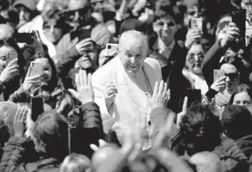  ?? FILIPPO MONTEFORTE/GETTY-AFP ?? Pope Francis greets the faithful at the end of Palm Sunday Mass in St. Peter’s Square at the Vatican. Francis called for an Easter truce in Ukraine. “A truce to reach peace through real negotiatio­ns,” he said. Palm Sunday is the beginning of Holy Week, which commemorat­es the arrival of Jesus Christ in Jerusalem, days before he was crucified.