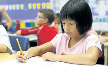  ?? JULIE JOCSAK/POSTMEDIA FILE PHOTO ?? Angela Thai, a Grade 3 student at Power Glen Public School in St. Catharines, works on class assignment­s in this file photo.