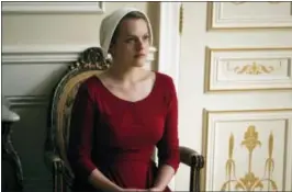  ??  ?? Elisabeth Moss as Offred in a scene from “The Handmaid’s Tale,” premiering Wednesday on Hulu with three episodes.