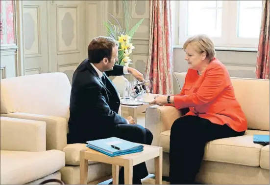  ?? LUDOVIC MARIN / AFP ?? Emmanuel Macron sirve café a Angela Merkel antes de iniciar su reunión en el palacio de Meseberg, al norte de Berlín