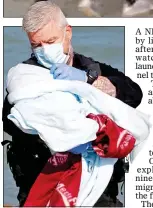  ?? ?? SAFE: The newborn baby is cradled by a police officer in Kent