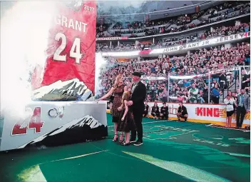  ?? JACK DEMPSEY/COLORADO MAMMOTH ?? John Grant Jr., with his wife Raygen and daughter Gabrayel, watches as his jersey, No. 24, is retired by the Colorado Mammoth during a pre-game ceremony in at the Pepsi Centre in Denver on Saturday night.