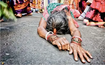  ??  ?? A woman takes part in the festival of Dondi that takes place during the summer. The devotees take a dip in the holy Ganges at Kalighat and go to the temple on hands and knees