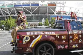  ?? SUSAN WALSH / AP ?? Rodney Johnson of Chesapeake, Virginia, sits on the back of his truck Monday outside FedEx Field in Landover, Maryland. Washington Redskins founder George Preston Marshall renamed the Boston Braves in 1933 and moved the team to D.C. four years later. A segregatio­nist, he was the last NFL owner to integrate his team.