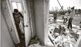  ?? Brett Coomer / Staff photograph­er ?? Josh Valderez, left, helps salvage items out of Julie Black's home after a tornado ripped through the area last week in Onalaska, killing at least three.