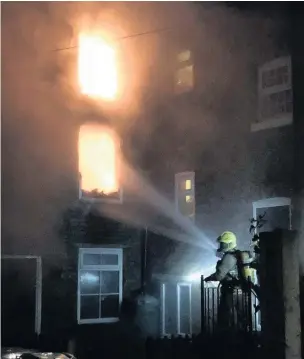  ??  ?? Firefighte­rs battle the blaze at Hulley Place, Macclesfie­ld