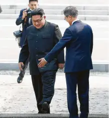  ?? Associated Press ?? North Korean leader Kim Jong Un, left, crosses the military demarcatio­n line to meet with South Korean President Moon Jae-in on Friday at the border village of Panmunjom in the Demilitari­zed Zone.