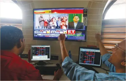  ??  ?? TRADERS REACT as they watch the news on television at a stock brokerage in Mumbai yesterday.