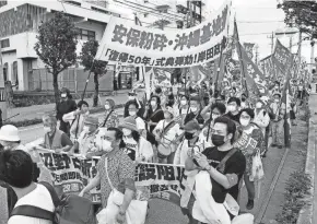  ?? KYODO NEWS VIA AP ?? Protesters march in Ginowan, Okinawa, on Sunday in opposition to the ceremony marking the 50th anniversar­y of the island’s return to Japan after 27 years of American rule.