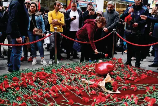  ?? — afp ?? People on Monday lay flowers at a makeshift memorial for victims the of explosion on the busy shopping street of Istiklal in Istanbul.