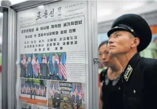  ?? /AFP ?? Too soon to tell: A conductor at a news stand on a subway platform in Pyongyang on Wednesday reads the Rodong Sinmun newspaper showing images of North Korean leader Kim Jong-un meeting with US President Donald Trump during their summit in Singapore on...