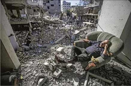  ?? A PALESTINIA­N MAN Majdi Fathi NurPhoto ?? sits among the ruins of his home in the Bureij refugee camp in the central Gaza Strip last month.