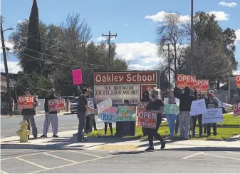  ?? Heather McKinney ?? Above: Parents rally outside Oakley City Hall against school closures after the mass resignatio­n of the city’s school board. Left: Kim Beede, shown in a screen grab of a video taken by a YouTube user who declined to be identified, was among four board members who resigned after they disparaged parents.