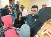  ?? MORGAN LEE/AP ?? Pastor Elias Rodriguez of Casa Nueva Voz, second right, meets immigrants Thursday as they seek refuge from cold weather in a shelter in Ciudad Juarez, Mexico.