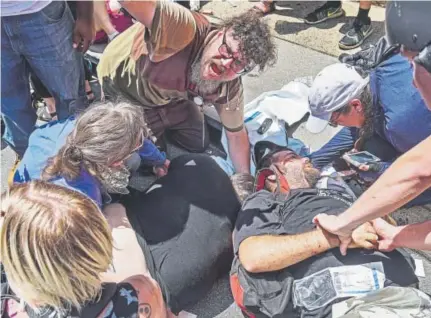  ?? Go Nakamura, The Associated Press ?? Responders care for victims struck by a car that plowed into a crowd of people who gathered to protest a white supremacis­t rally in Charlottes­ville, Va., on Aug. 12. The suspect is James Alex Fields Jr.