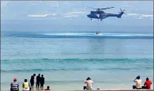  ?? PICTURE: AP ?? AERIAL REINFORCEM­ENT A helicopter collects water in the ocean off Hout Bay in a frantic attempt to douse the fire.