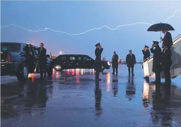  ??  ?? STORMY WEATHER: Donald Trump disembarks from Air Force One as lightning splits the sky during a storm at Andrews Air Force Base near Washington.