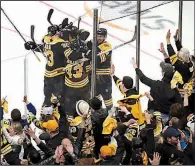  ?? AP/CHARLES KRUPA ?? Boston fans celebrate as players gather to congratula­te center Sean Kuraly on his third-period goal Tuesday as the Bruins defeated the Toronto Maple Leafs 5-1 in Game 7 of their NHL Eastern Conference playoff series in Boston.