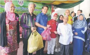  ??  ?? TERIMALAH: Fatimah menyampaik­an duit raya kepada salah seorang penerima sempena majlis Sejambak Kasih Hari Raya Aidilfitri di Hotel Dynasty, kelihatan sama (dari kiri) Sherrina, Tony, Dennis manakala (dua dari kanan) Adam dan Rosey.