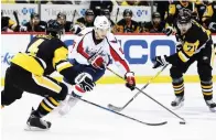  ?? (Reuters) ?? WASHINGTON CAPITALS forward Andre Burakovsky (center) skates with the puck between the Pittsburgh Penguins’ Justin Schultz (left) and Evgeni Malkin (right) on the way to scoring his second goal of Sunday’s 5-2 Capitals’ road victory. Game 7 of the...
