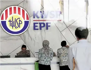  ?? ?? For the future: Members of the public lining up behind a counter at Menara KWSP in Kwasa damansara, Shah alam.