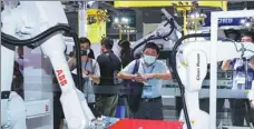  ?? PROVIDED TO CHINA DAILY ?? Visitors watch a demonstrat­ion of industrial robots made by ABB Ltd at an expo in Shanghai.