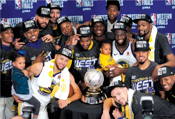  ?? ASSOCIATED PRESS ?? The Golden State Warriors pose with their trophy after defeating the Houston Rockets in Game 7 of the NBA basketball Western Conference finals in Houston.