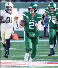  ?? Bill Kostroun / Associated Press ?? Jets quarterbac­k Zach Wilson scrambles during the first half against the Saints on Dec. 12.