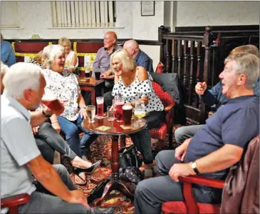  ?? AFP ?? Revelers put down pints of beer as pubs reopen in England despite fears of disorder and virus cases.