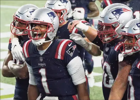  ?? Charles Krupa / Associated Press ?? Patriots quarterbac­k Cam Newton, left, celebrates his rushing touchdown with teammates in the second half on Sunday.