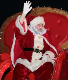  ??  ?? Santa Claus waves to the crowd during the Christmas parade.