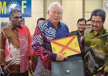  ?? [FOTO BERNAMA] ?? Najib memasukkan teks ucapan Bajet 2017 ke dalam beg ketika meninjau persiapan akhir Bajet 2017 di Kementeria­n Kewangan, malam tadi.