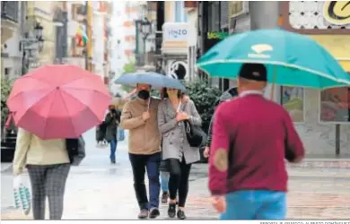  ?? REPORTAJE GRÁFICO: ALBERTO DOMÍNGUEZ ?? Un grupo de transeúnte­s por las calles del centro.