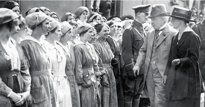  ??  ?? > British Prime Minister David Lloyd George inspecting munitions workers during a visit to a fatory in Neath, Wales in 1918