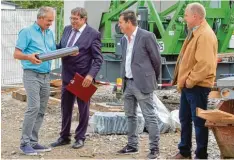  ??  ?? Die drei Bürgermeis­ter Josef Schreier, Fabian Streit und Peter Kellerer (von links) übergeben die Zeitkapsel an Alfons Rauscher (links) von der Rauscher Bau GmbH.