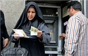  ?? AFP ?? People withdraw money from an automated teller machine in tehran’s grand bazar. —
