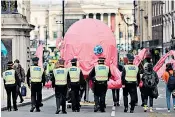  ??  ?? Stanley Johnson, the Prime Minister’s father, addresses demonstrat­ors to offer his support. Left, police officers follow activists with a large pink octopus in Whitehall