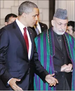  ?? — REUTERS ?? Barack Obama and Hamid Karzai walk together after signing the Strategic Partnershi­p Agreement in Kabul.