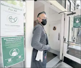  ?? RAY CHAVEZ — STAFF PHOTOGRAPH­ER ?? Daniel Torres, manager of Arbor restaurant in San Francisco, stands in the patio entrance alongside posters displaying COVID-19 vaccinatio­n and mask requiremen­ts on Wednesday, two days before the city’s indoor vaccine mandate took effect.