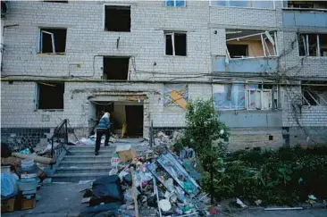  ?? NATACHA PISARENKO/AP ?? A resident enters what’s left of her home Tuesday in the wake of shelling in Borodyanka, Ukraine.