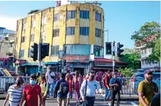  ?? ?? Pedestrian­s cross a road at the commercial hub of Pettah, Colombo. Tokyo considered Colombo’s economic recovery as crucial for the entire region. The island is located halfway along the main east-west internatio­nal shipping route.