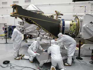  ?? NASA / Glenn Benson ?? Workers inside the Astrotech Space Operations Facility in Titusville, Fla., open and extend one of the solar arrays on NASA’s Lucy spacecraft on Aug. 19.