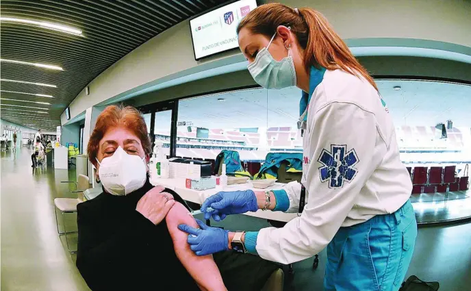  ?? EFE ?? Una sanitaria vacuna a una mujer en el Estadio Wanda Metropolit­ano, de Madrid