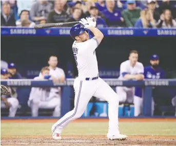  ?? TOM SZCZERBOWS­KI/GETTY IMAGES ?? The Blue Jays’ Brandon Drury hits a two-run walk-off homer in the ninth Friday in Toronto against the Oakland A’s. On Sunday, he hit a game-tying three-run belt in the 11th inning.