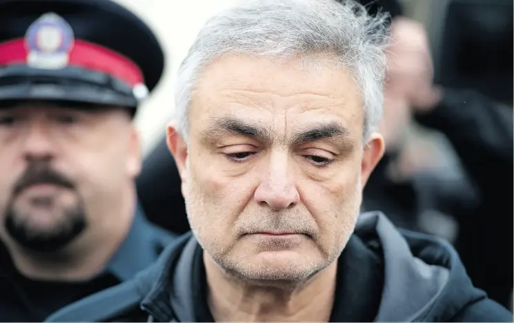  ?? PETER J. THOMPSON / NATIONAL POST ?? Vahe Minassian, father of the alleged van attacker, is escorted by police from a Toronto courthouse on Tuesday. Alek Minassian has been charged with 10 counts of murder. The younger Minassian lived with his parents and his brother in a detached...