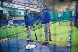  ??  ?? Lucas Stoll, 13, of St. MIchael’s High School, gets instructio­n from Narci Saiz, a coach at St. Mike’s, during E&G Baseball Academy.