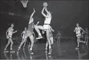  ?? MATTY ZIMMERMAN — THE ASSOCIATED PRESS FILE ?? In this Nov. 10, 1949, file photo, Alex Groza (15) blocks a shot attempt by center Connie Simmons (6) of the New York Knickerboc­kers, during second quarter of game with Indianapol­is Olympians at Madison Square Garden in New York City.